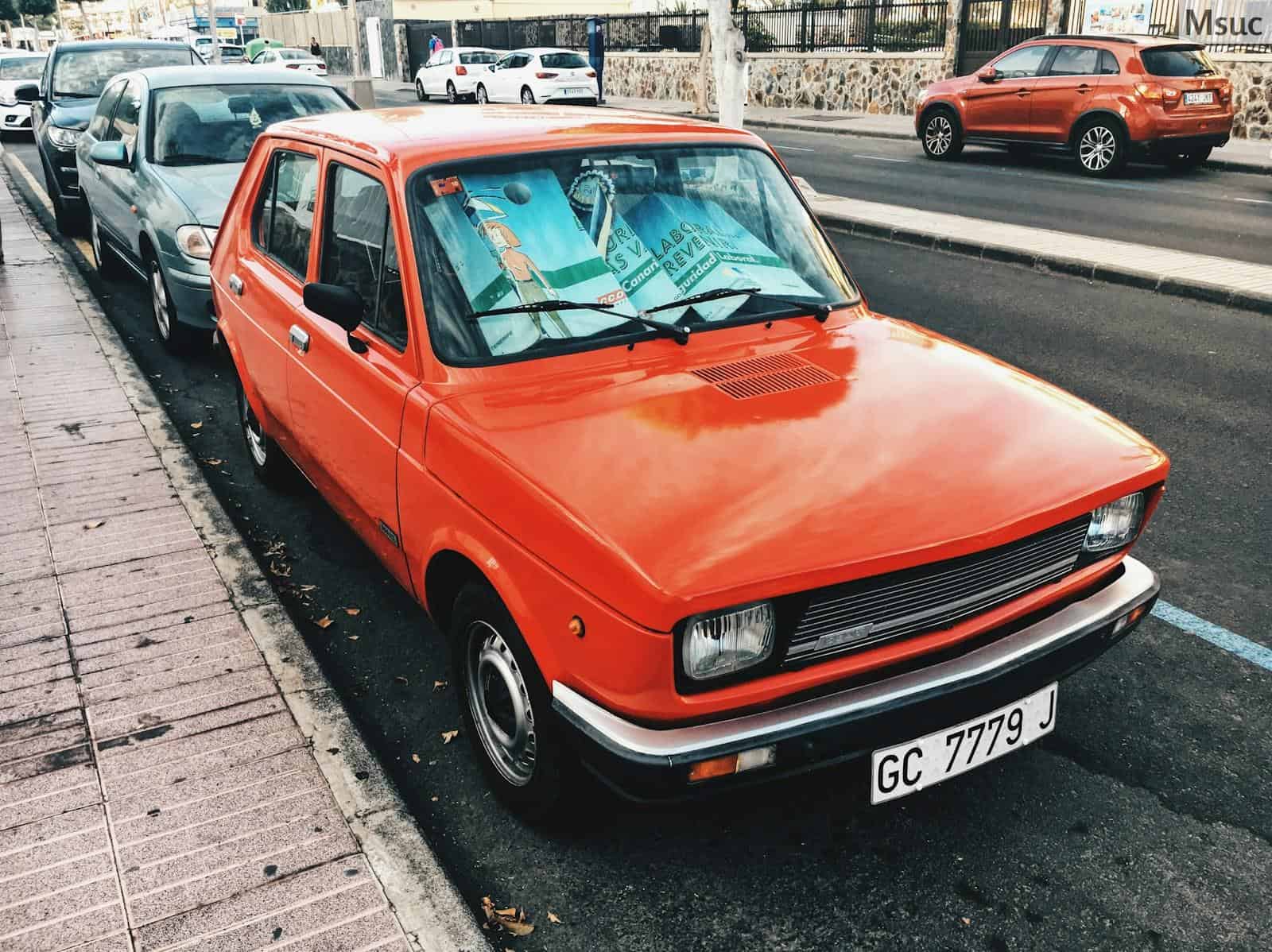 red 5-door hatchback parked near concrete curb